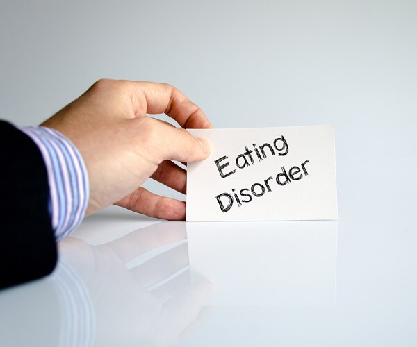 a hand holding a card that reads eating disorder