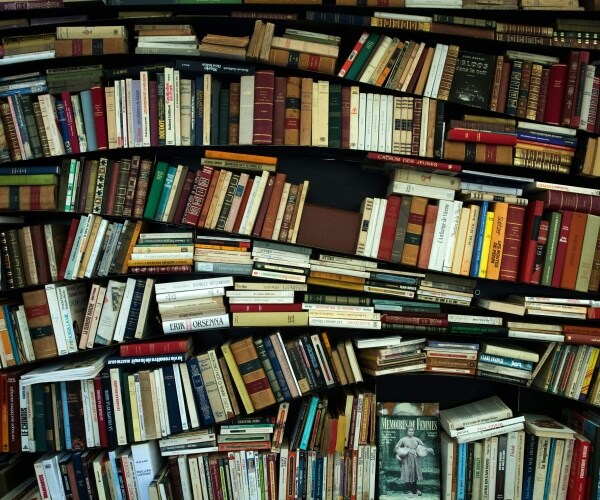 curved bookshelf with hundreds of books stacked inside