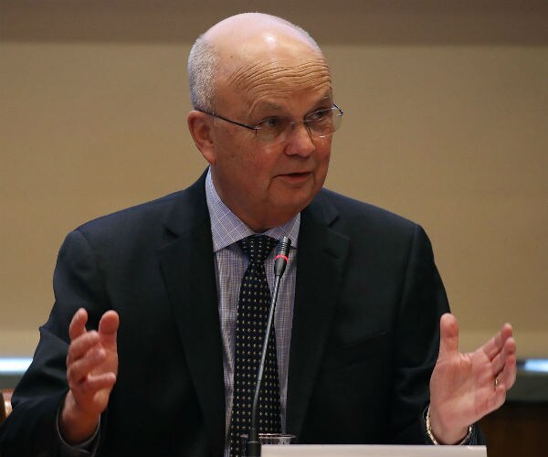 michael hayden, bald and wearing glasses, gestures with both hands palms up while delivering remarks at a hearing