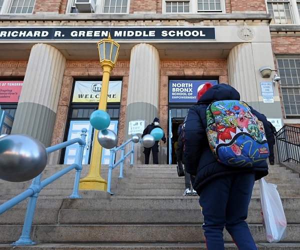 student walks up steps to school