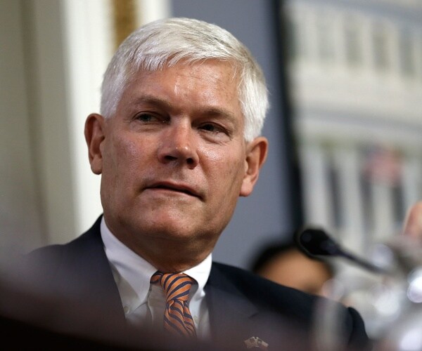 sessions in a suit and orange striped tie