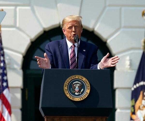 president donald trump gestures at a podium on the white house lawn