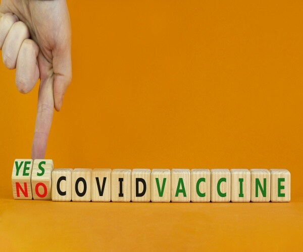 Photo of blocks that spell out COVID vaccine and a yes and a no block. 