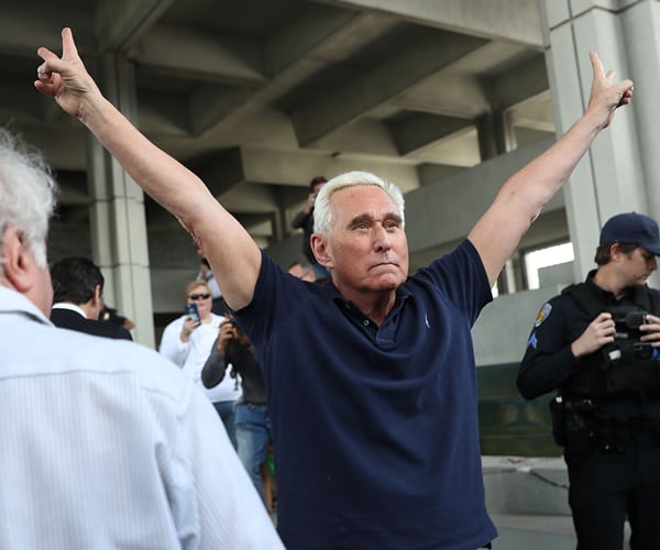 roger stone shows the victory sign outside of a courthouse