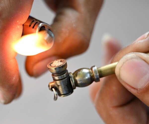 a man's hands light a crack pipe.