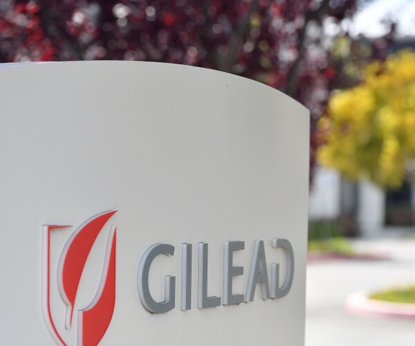 gilead sciences sign with logo outside with trees in the background