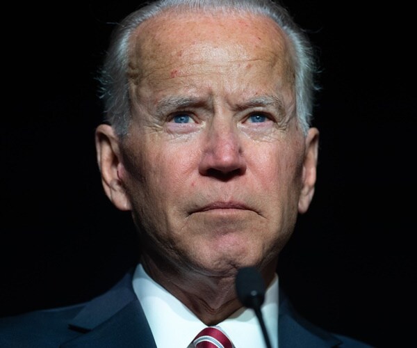 joe biden speaks against a dark background