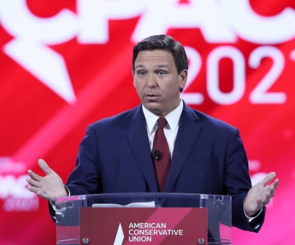 ron desantis speaks against a cpac backdrop