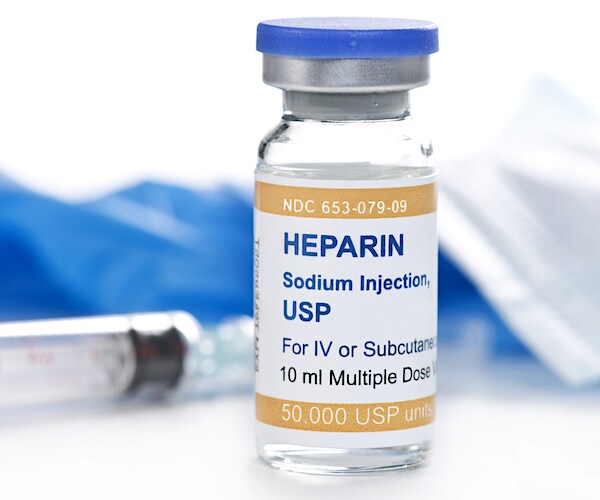 a syringe and a heparin vile of medicine on a table