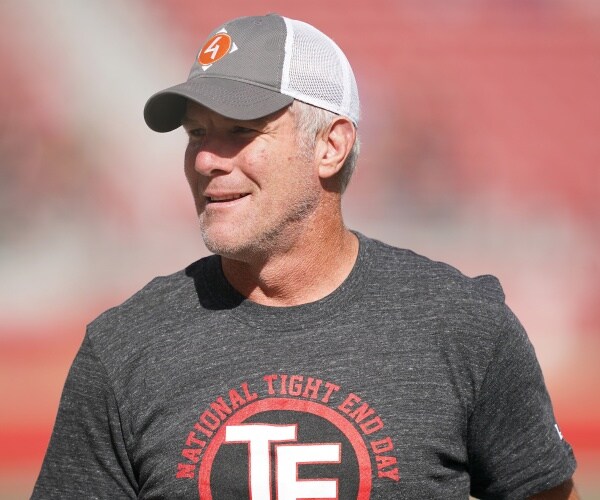 favre in a gray t shirt and baseball hat