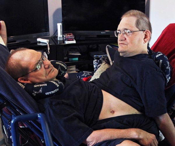 galyon conjoined twins sit down wearing black t shirts