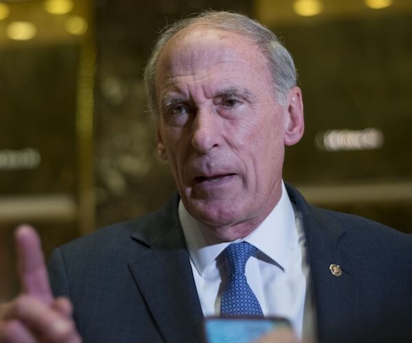 dan coats walks through trump tower, stopping for an interview with the media