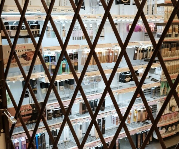  a gate is used to lock items at a pharmacy and convenience store 