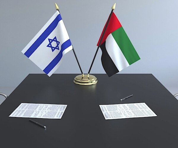 the flags of israel and the united arab emirates at a table with a peace deal in an illustration