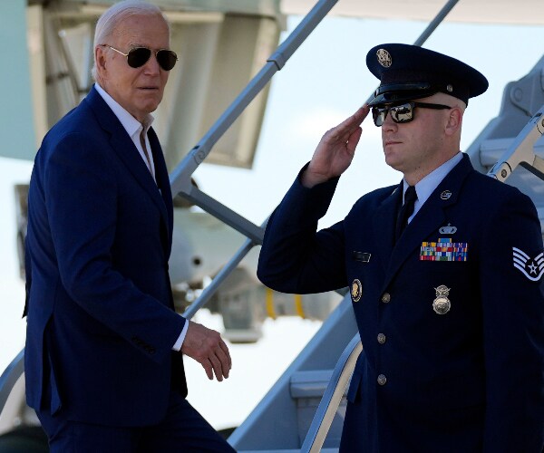 President Joe Biden looks over while climbing stairs to air force one