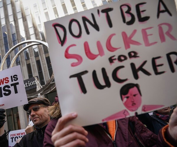 protesters outside fox news with signs against tucker carlson and fox news