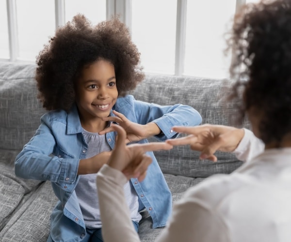 young girl signs with mother