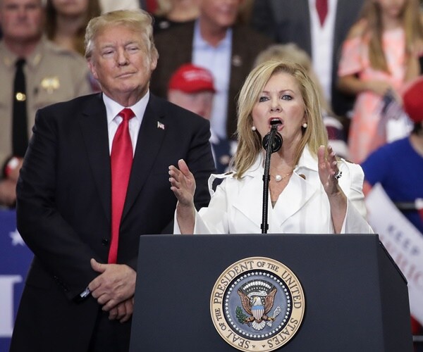 marsha blackburn speaks at rally as president trump look on.