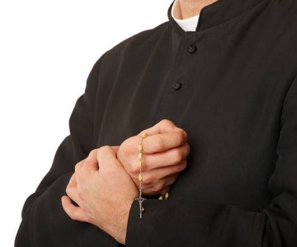 a priest holds a rosary