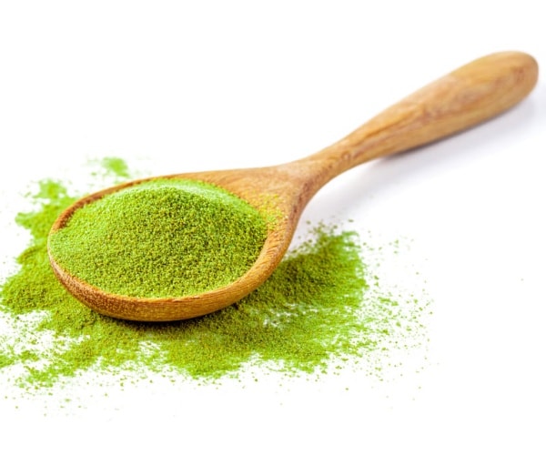 matcha green tea powder on a wooden spoon