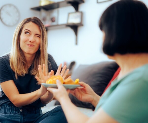 woman saying no to a plate of food