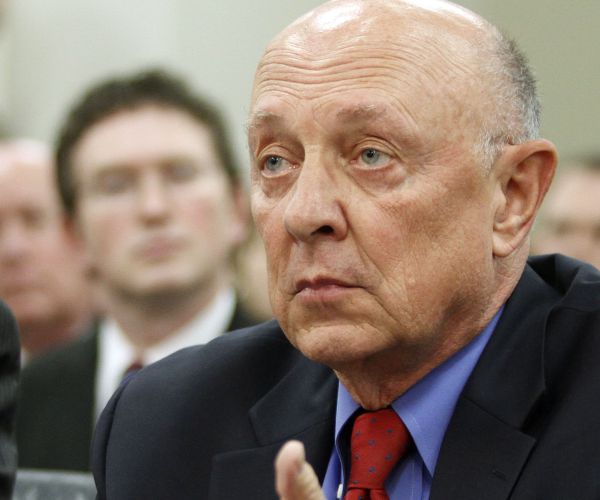 james woolsey sits and listens during a congressional hearing appearance