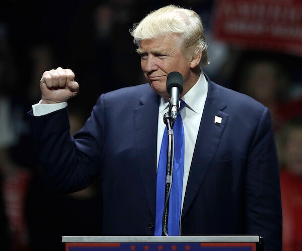 president donald trump pumps his fist during a campaign rally