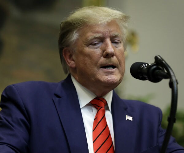 president donald trump is shown in blue suit, white dress shirt, red and blue tie 