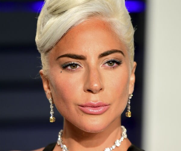 lady gaga is seen in a black dress with a large diamond necklace and matching earrings