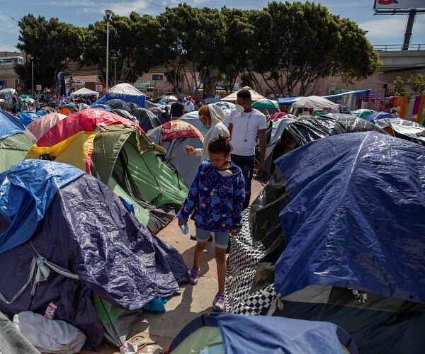 child walks through tent city