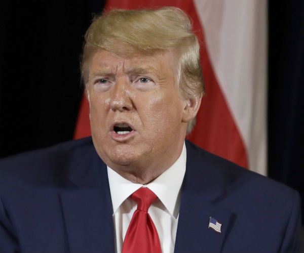 president donald trump is shown in a blue suit, white dress shirt and red tie