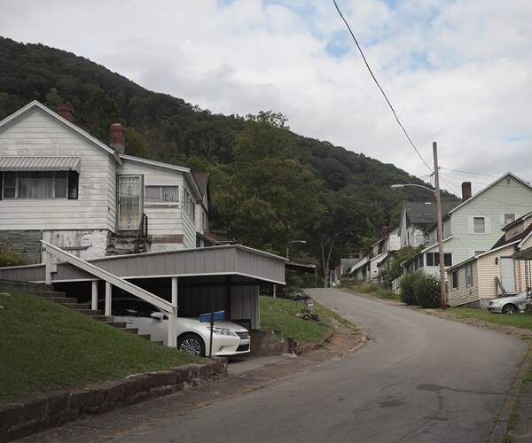 houses on a street leading up to a mountain where coal is mined