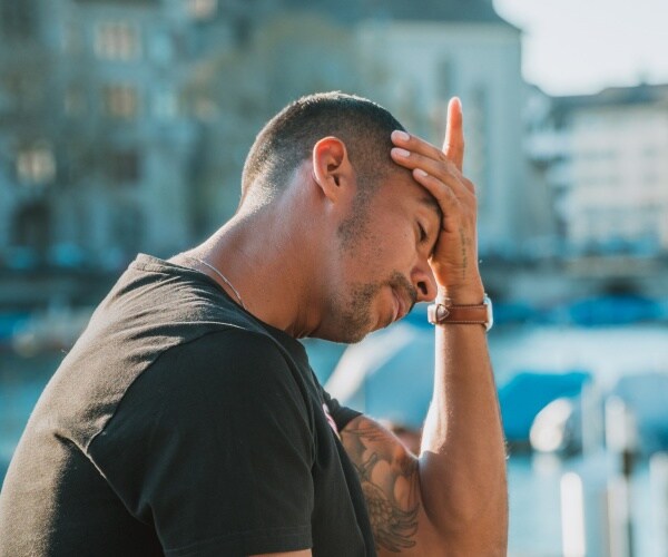 man with head in hands looking depressed, sad