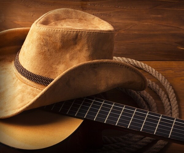 cowboy hat sits on guitar