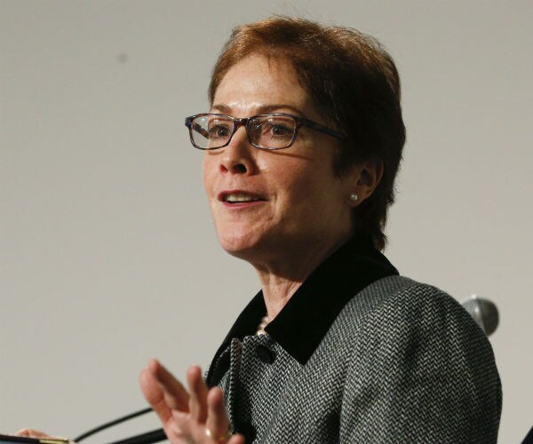 Marie L. Yovanovitch is shown speaking at a podium in a tweed jacket