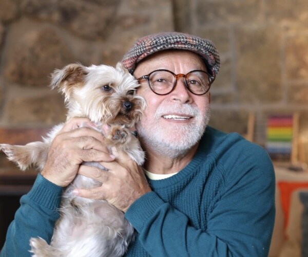 older man holding small dog