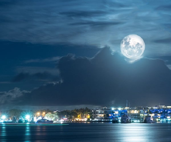 bright moon over city lights