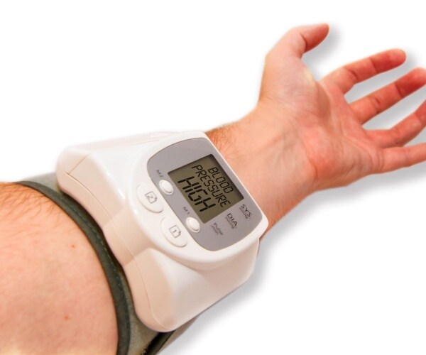 man's arm with a monitor that says 'blood pressure HIGH'