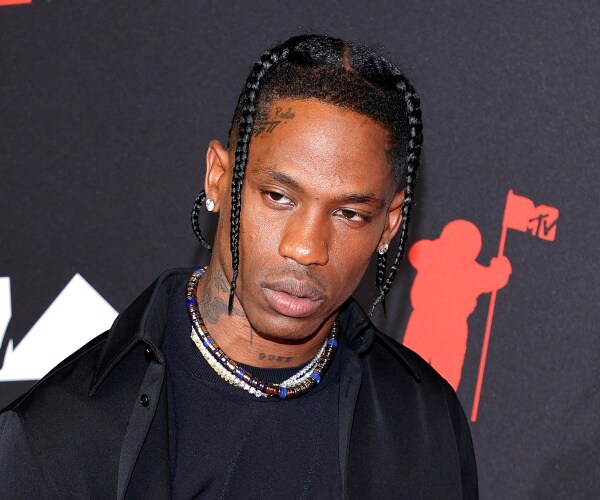 travis scott stands on red carpet