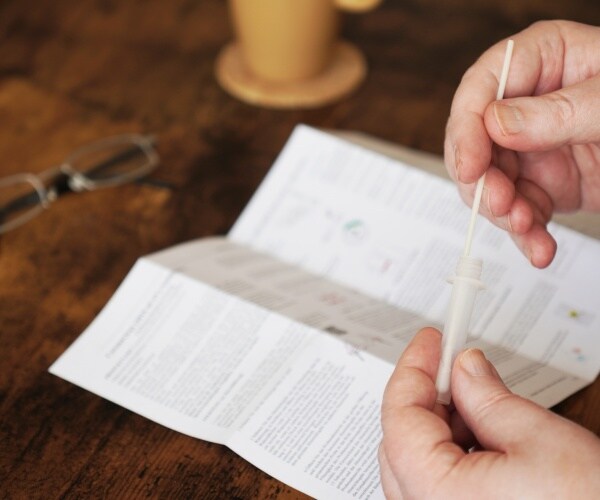 Man reads directions for rapid at-home COVID test