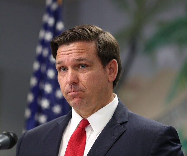 desantis in a navy blue suit and red tie