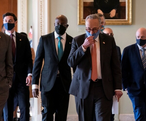 a group of senators walk down hallway