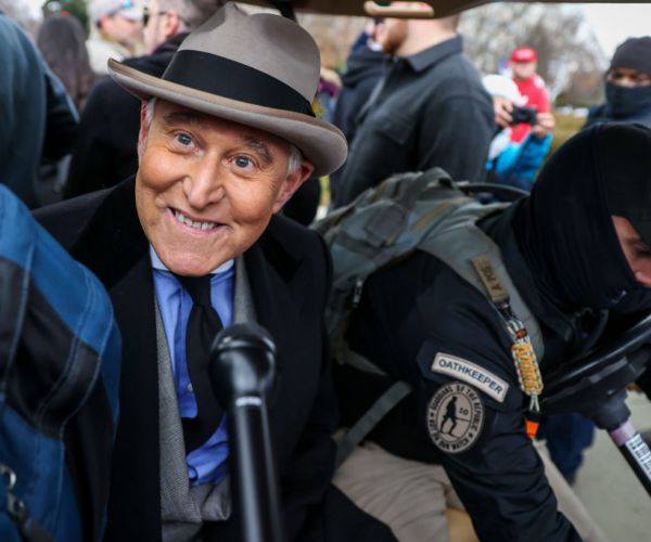 roger stone smiles with his trademark traditional top hat