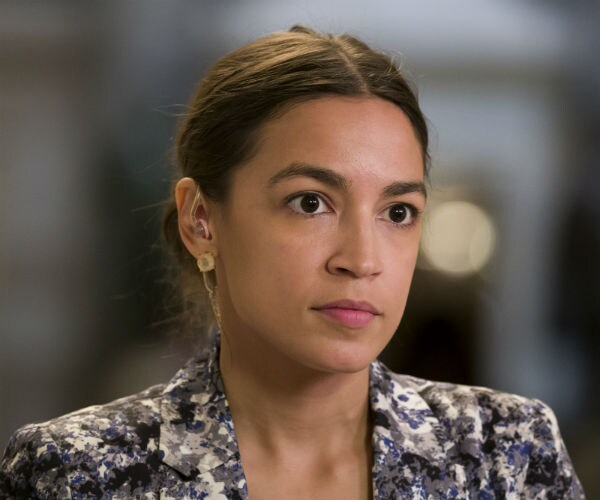 Rep. Alexandria Ocasio-Cortez is seen in a floral dress with her hair pulled back