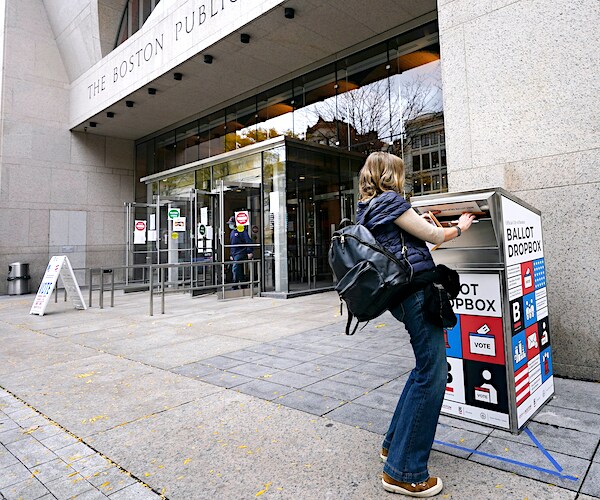 Voter Linda Borman drops her ballot into the ballot box outside the Boston Public Library on Monday