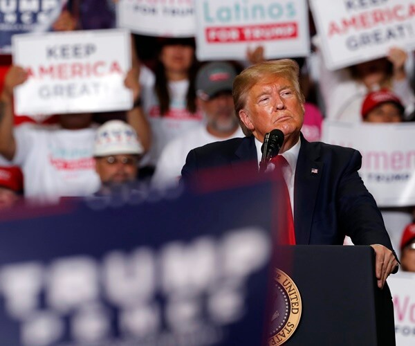 president donald trump takes a beat at te podium during a campaign rallly