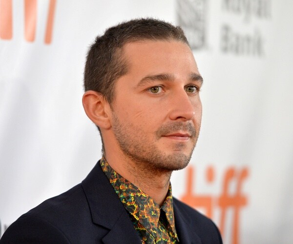 shia labeouf stands on red carpet