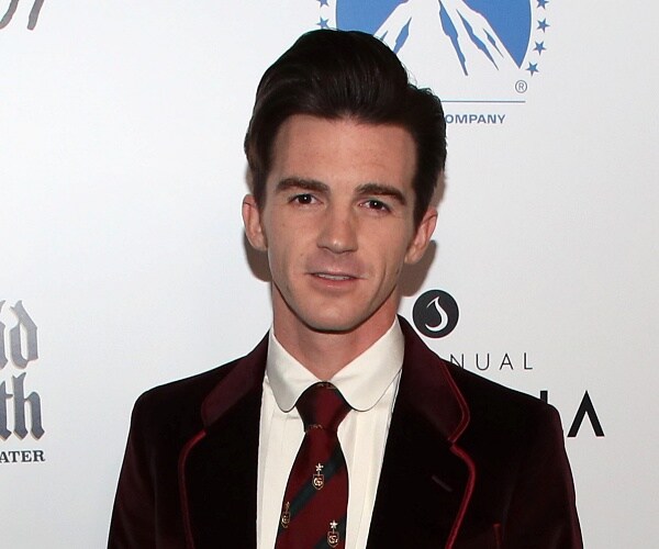 drake bell stands on red carpet