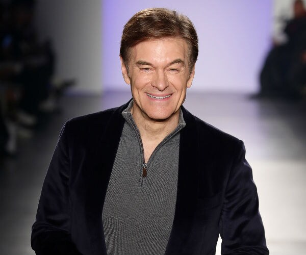 dr. oz is shown in black jacket, grey and black sip up shirt and blue trousers