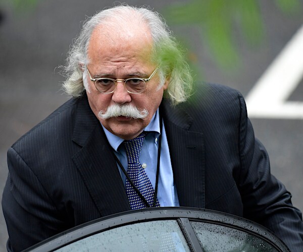 a gray haired, balding and wearing an handlebars mustache ty cobb delivers remarks behind and outdoor podium